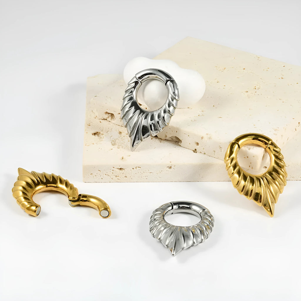 Stainless steel drop-shaped auricle ear extender with totem design on a white background.