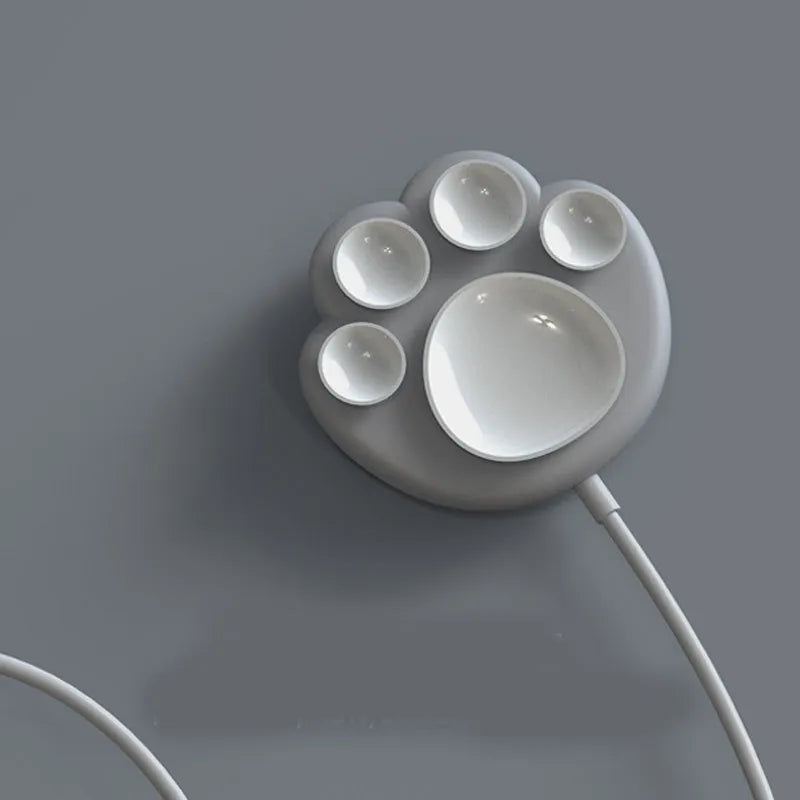 Pink cat claw sucker wireless charger on a desk with USB cable attached