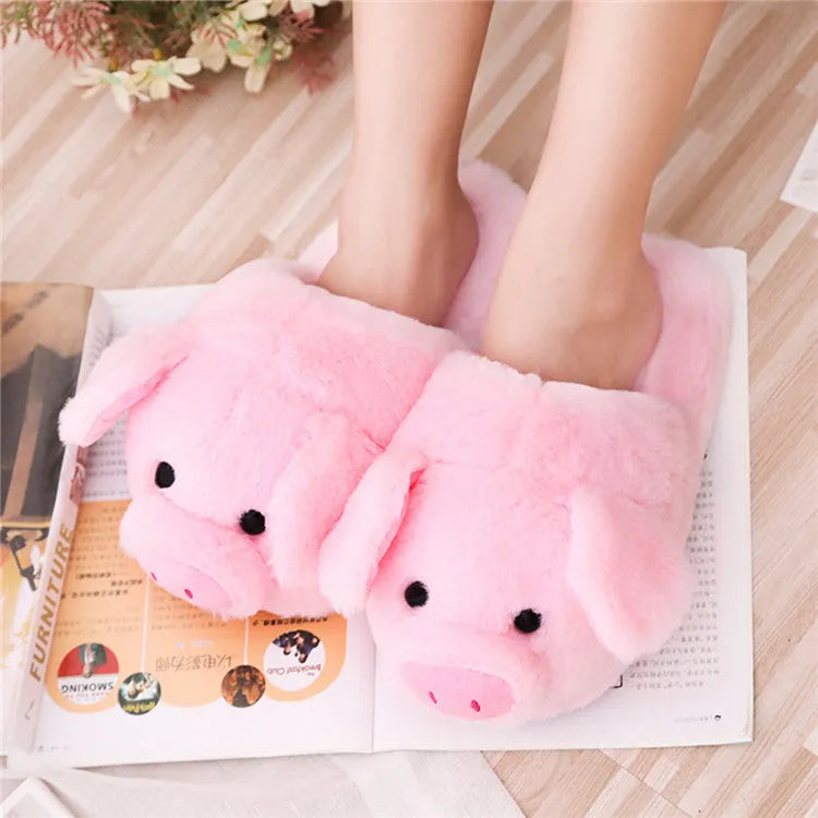 Pink pig-shaped plush floor slippers on a white background.