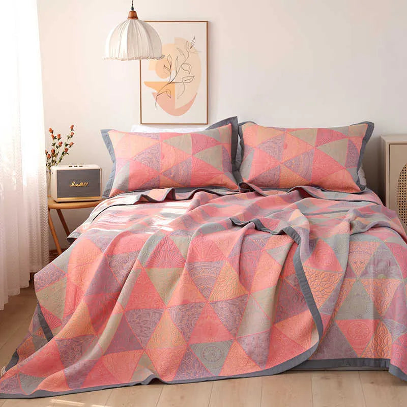 Cotton gauze floral blanket and two matching pillowcases laid out on a bed.