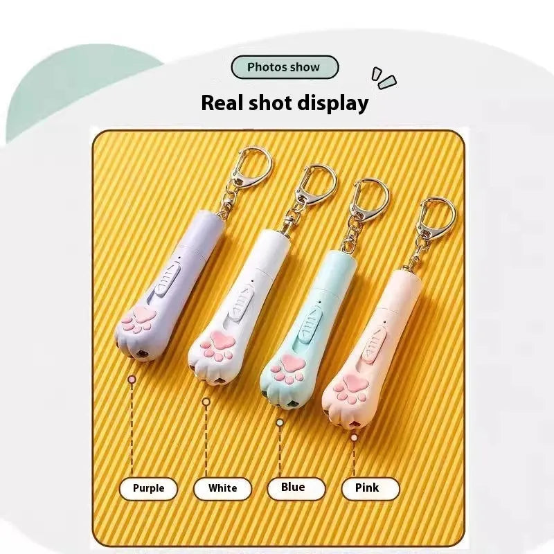 Pink self-playing cat teaser wand toy with USB charging cable on a table.