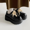 Women's matte black lace-up platform ankle boots with a thick sole and round toe.