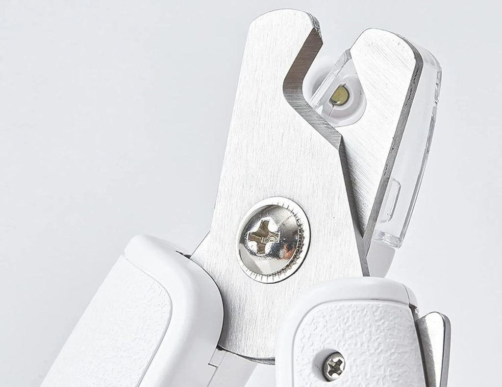 White pet nail clippers with LED light, transparent guard, and built-in file for cats and dogs.