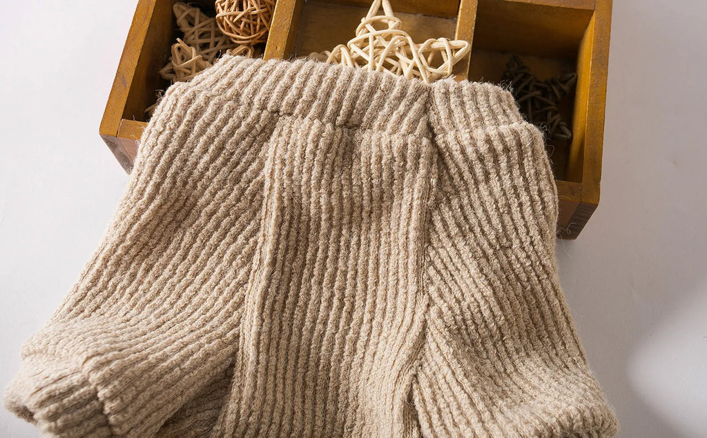 A brown knitted pullover sweater for a small dog on a mannequin.