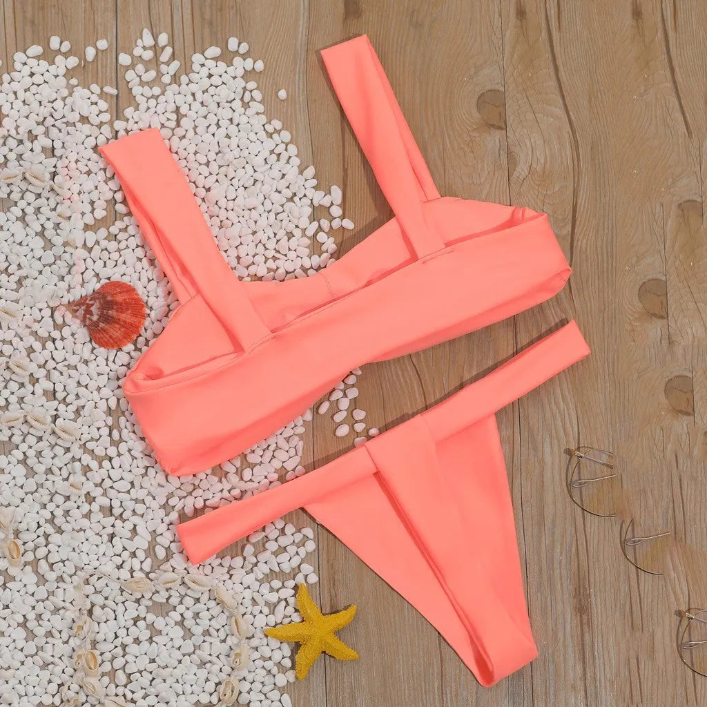 Solid colour split bikini swimsuit in orange on a model, showing two-piece design with nylon fabric