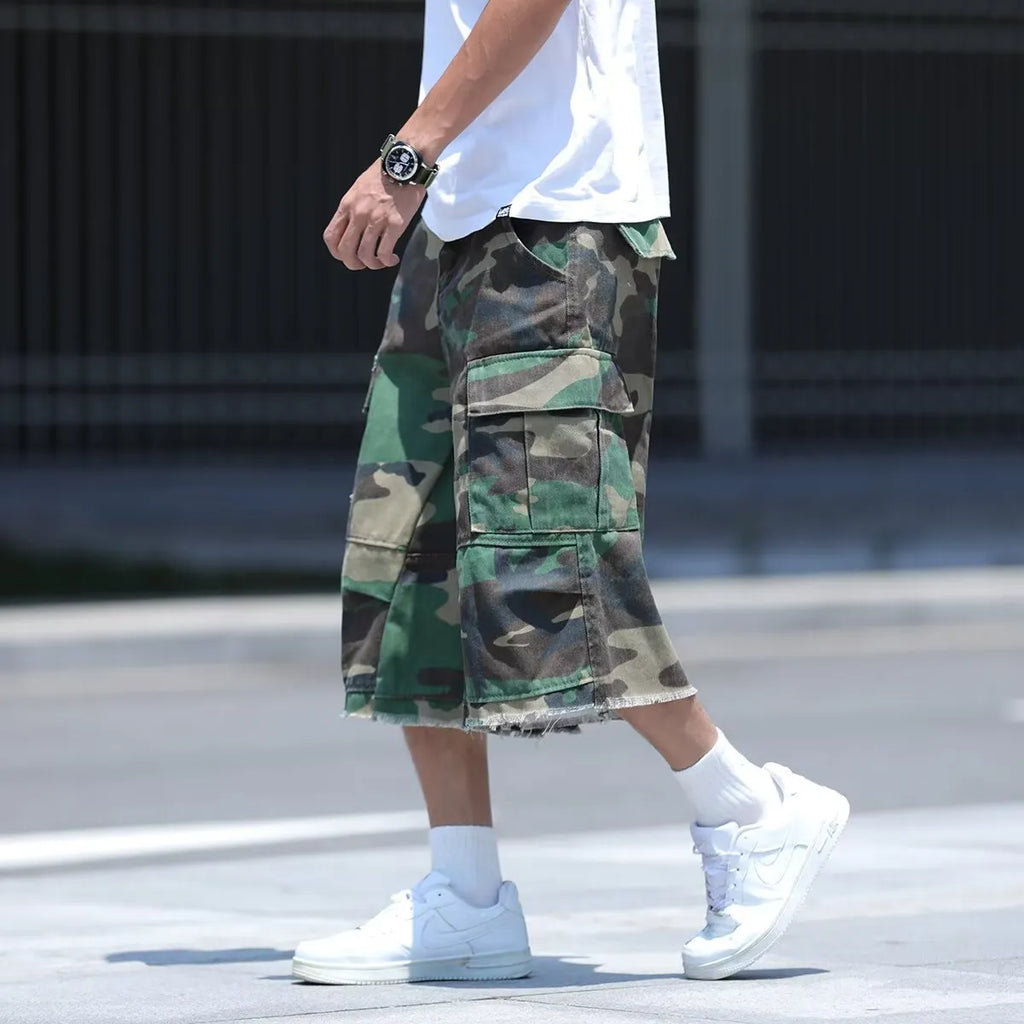 Man wearing loose fit camouflage retro workwear shorts in a khaki camouflage pattern.