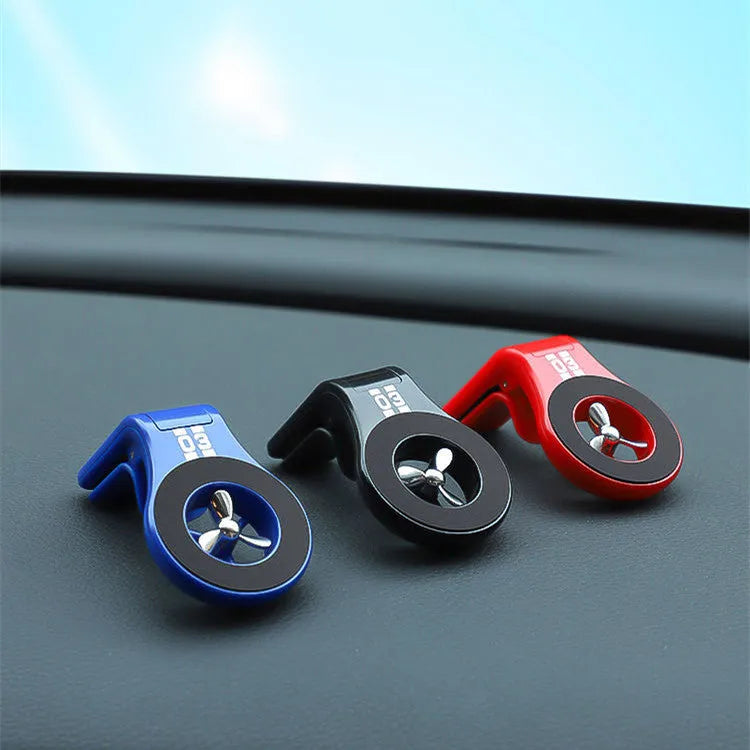 Black magnetic car air vent phone holder with adjustable head and fragrance slices attached to a vehicle vent.