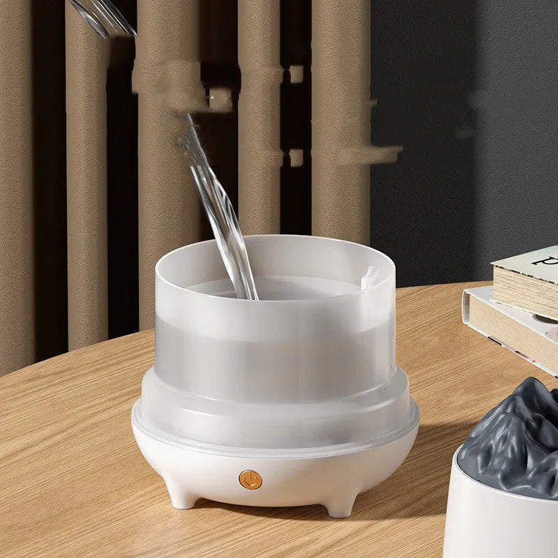 White volcano-shaped USB humidifier emitting mist on a wooden desk