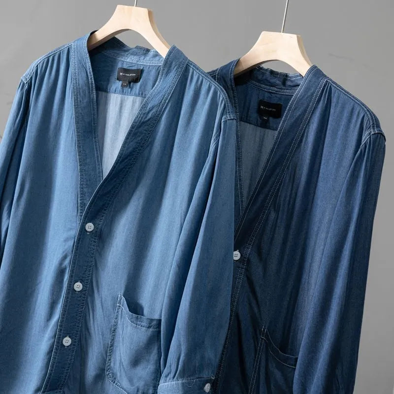 Men's dark blue V-neck denim coat with three-quarter sleeves showing loose fit and pocket detail
