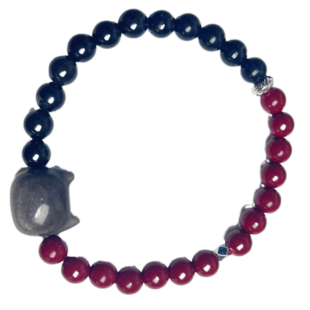 Handmade obsidian bead bracelet with a small cat charm on a cord.