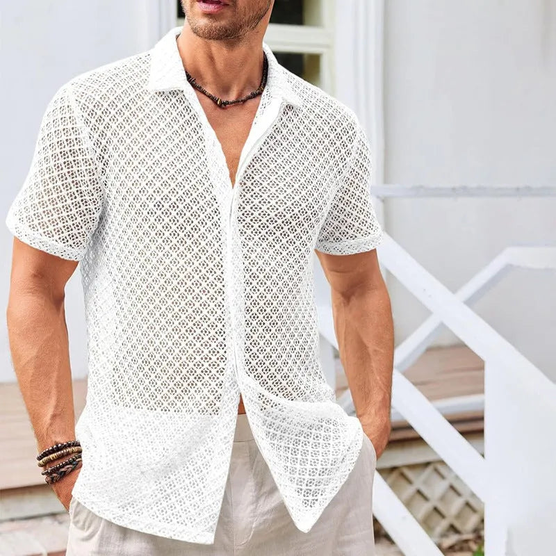 Man wearing a beige loose-fit short sleeve mesh lapel shirt on a beach.