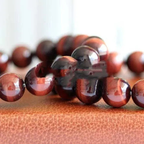 Red tigereye wood alexandrite bracelet with lightning cat's eye pattern on wrist.
