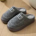 Men's brown suede slippers with a thickened sole on a wooden floor