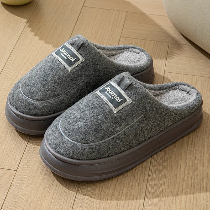Men's brown suede slippers with a thickened sole on a wooden floor