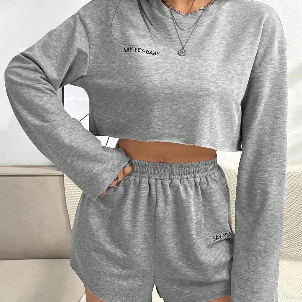 Grey women's polyester tracksuit set with long sleeve t-shirt and matching shorts laid flat.