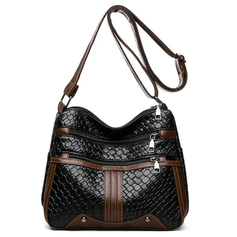 Horizontal square messenger bag with multiple compartments and woven shoulder strap in black with brown trim