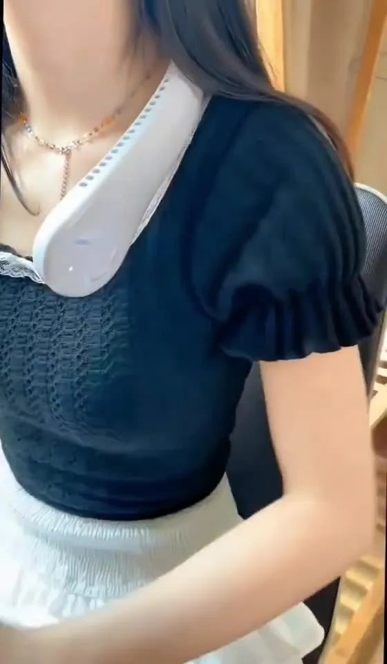 White portable bladeless neck fan hanging around a neck with USB charging cable.