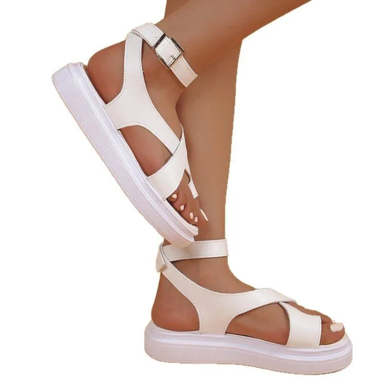 Women's white thick-soled Roman sandals with an ankle buckle fastener on a lace loop.