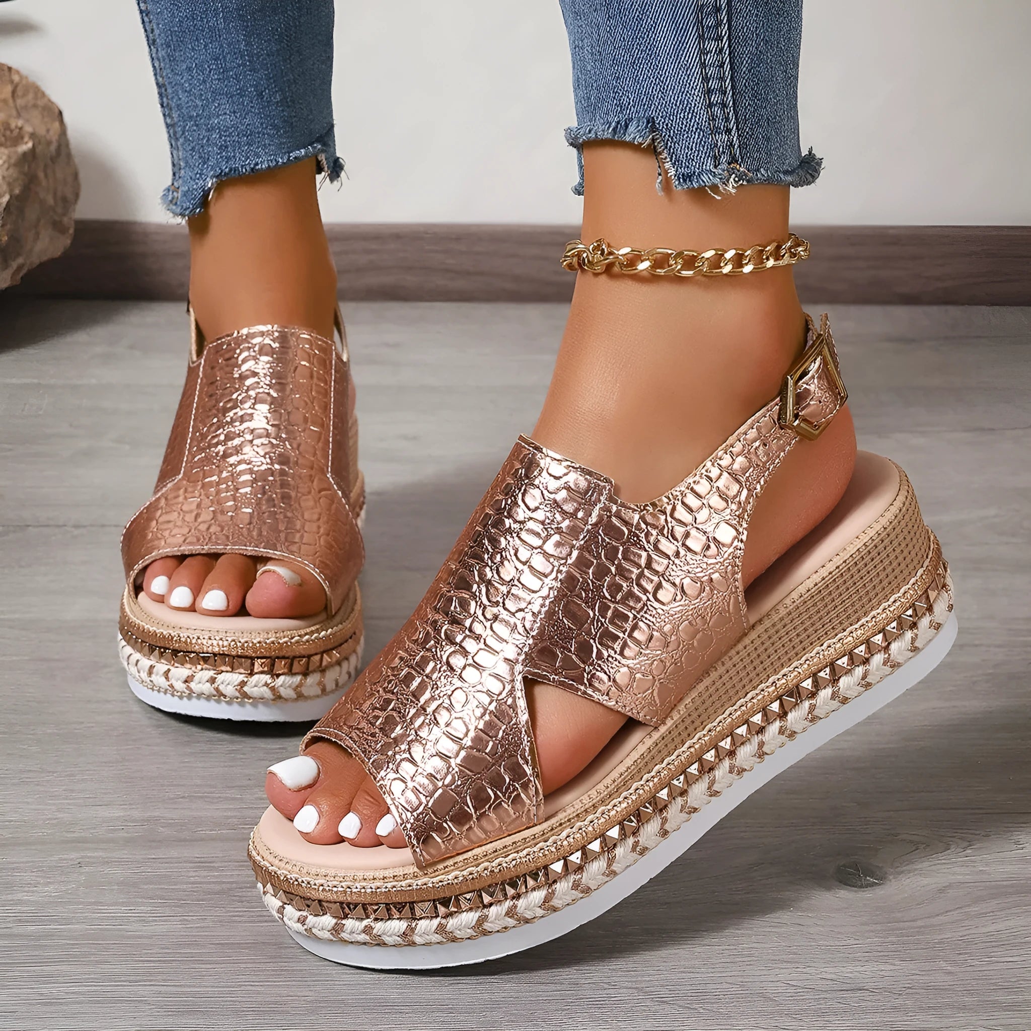 Gold women's Roman sandals with round toe, ankle buckle, and hollow-out design on a rubber sole.