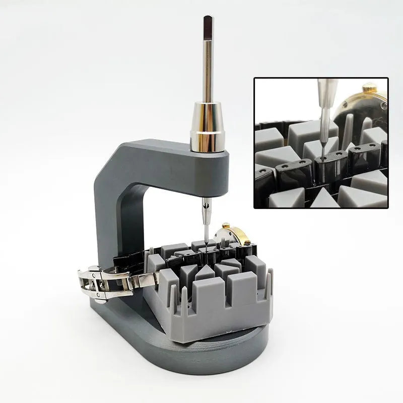 Silver tool steel press strap removal tool for watch and jewellery repair on a workbench.