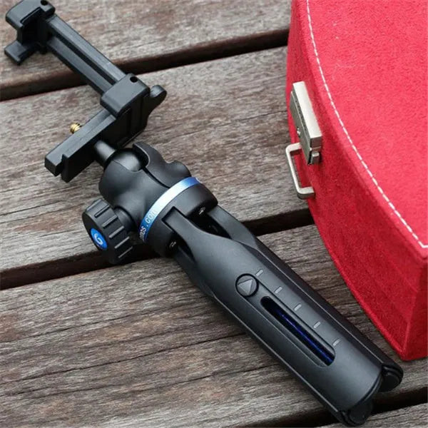 Black desktop mobile phone tripod stand holding a phone, showing adjustable angle bracket.