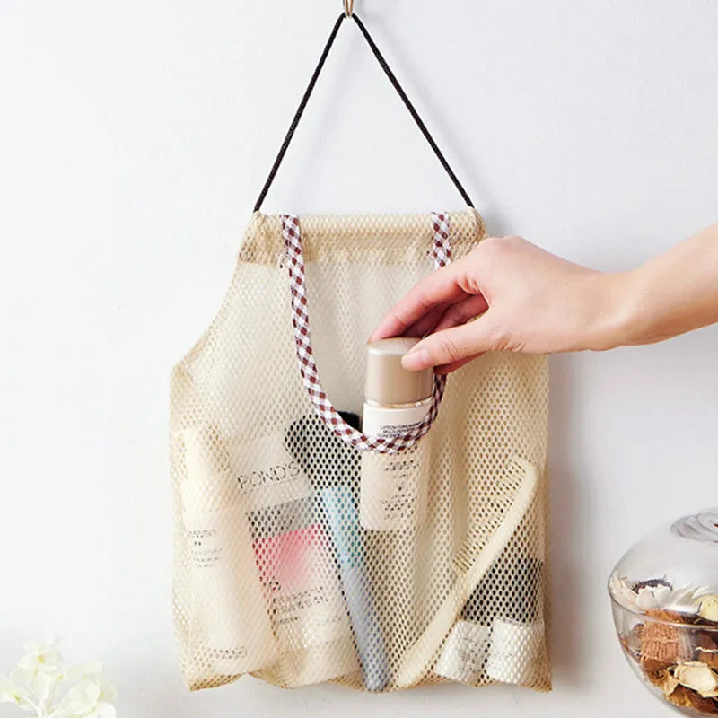 Beige plaid polyester mesh storage bag with cotton rope hanging loop on a white wall