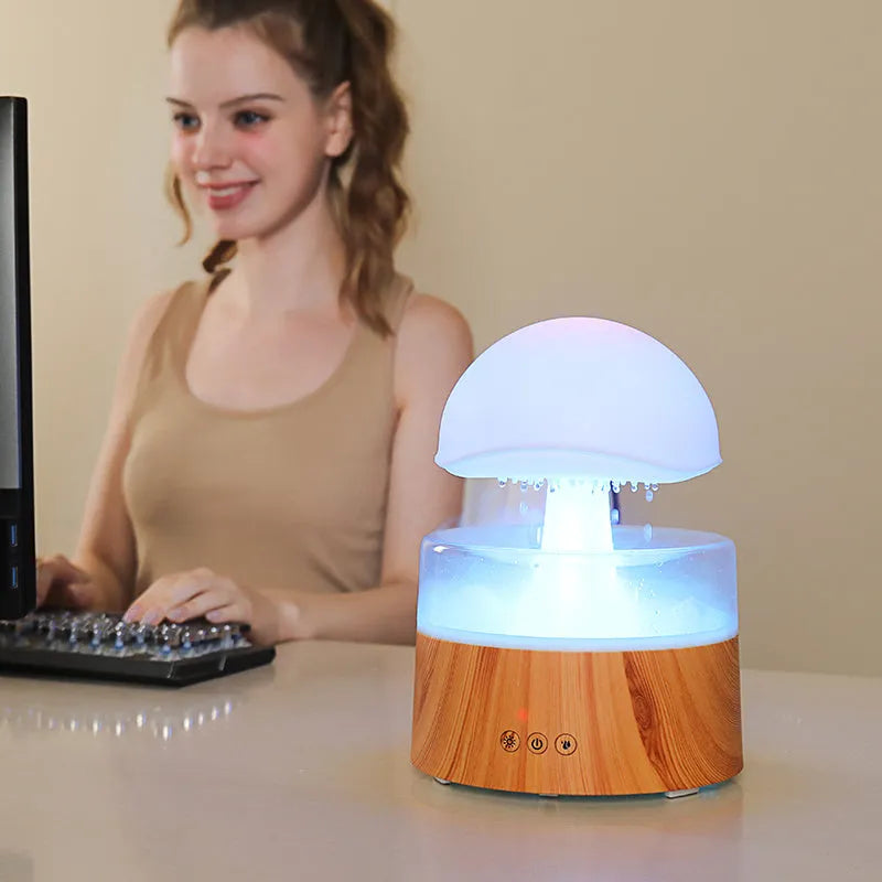 White cloud-shaped humidifier and aroma diffuser with LED lights and simulated raindrops.