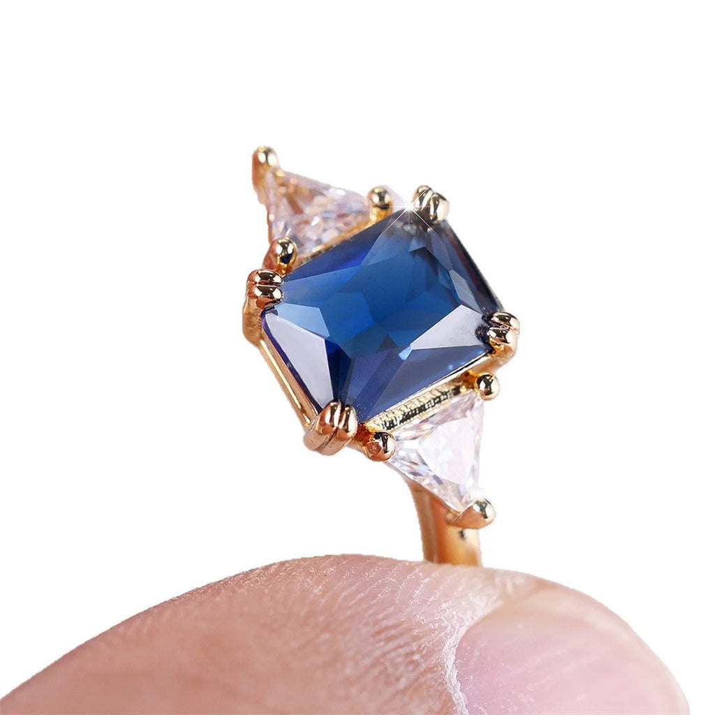 Rectangular copper ring with gold sapphire blue finish shown on model finger