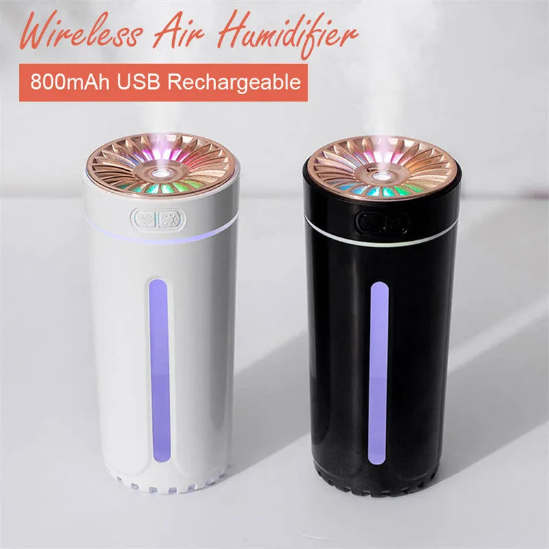 Black and white portable USB rechargeable car humidifier with colourful LED lights on a desk.
