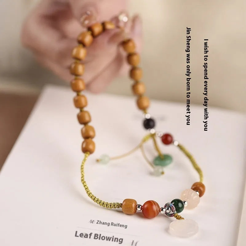 Women's hand-woven ebony double ring bracelet with traditional Ruyi motifs in Xiuyan jade or antique chalcedony