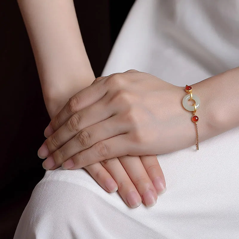 Gold-coloured women's bracelet with inlaid green Hetian jade stone and an adjustable peace buckle clasp.