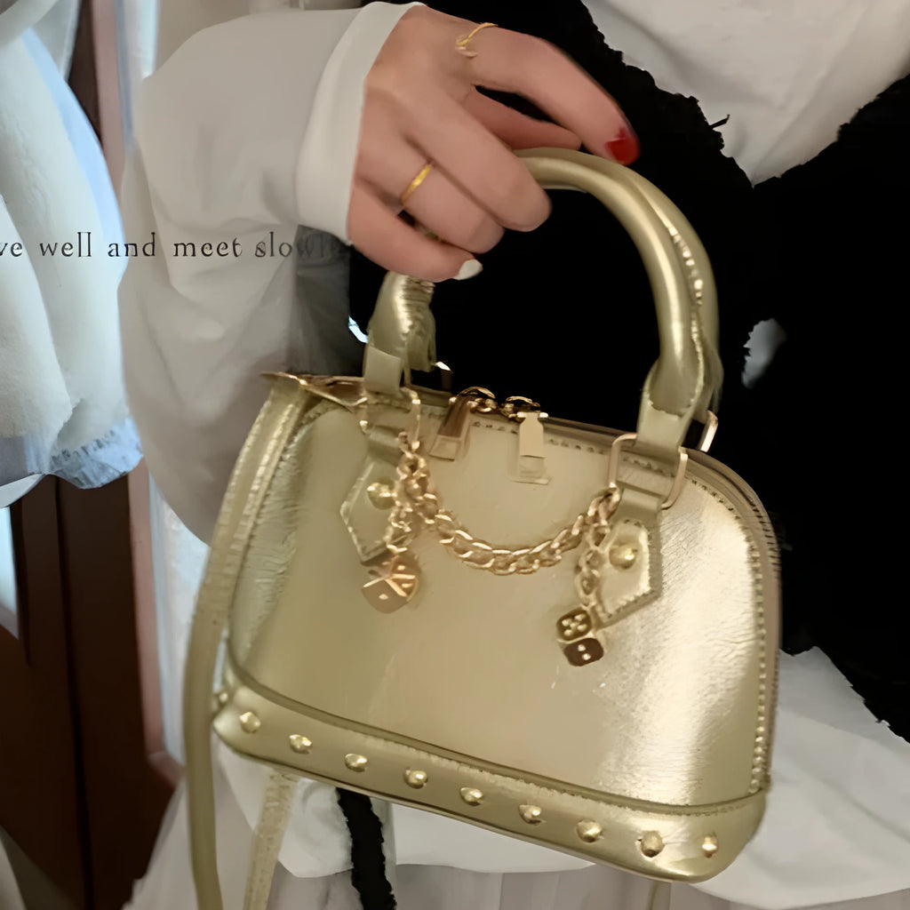 Champagne-gold PU shell bag with stitched seams, worn as a shoulder bag against a neutral background