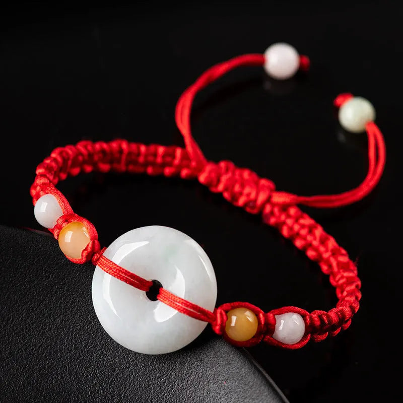 Round emerald jade pendant on adjustable red cord bracelet