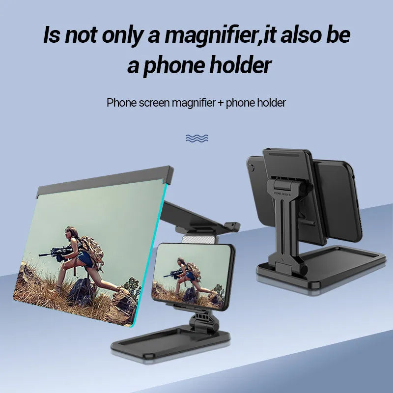 Black detachable mobile phone screen amplifier and folding holder shown on a desk next to a phone.