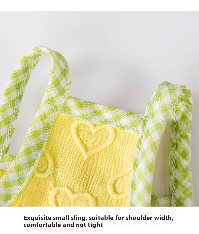 Small dog wearing a blue elastic suspenders vest with a heart-texture bow.