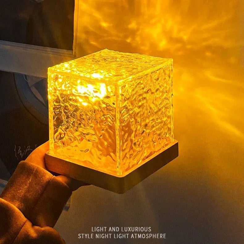 Water ripple crystal table lamp projecting coloured light patterns on wall