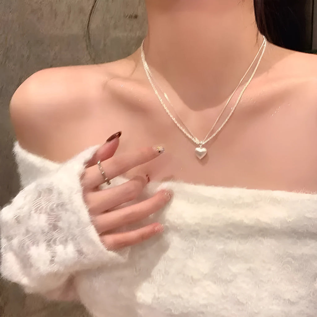 Double-layer heart pendant necklace in brushed silver finish with adjustable chain
