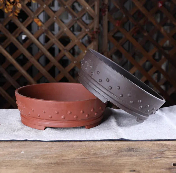 Chinese style indoor tabletop drum nail purple clay ceramic flowerpot with breathable design in purple clay colour on a wooden surface
