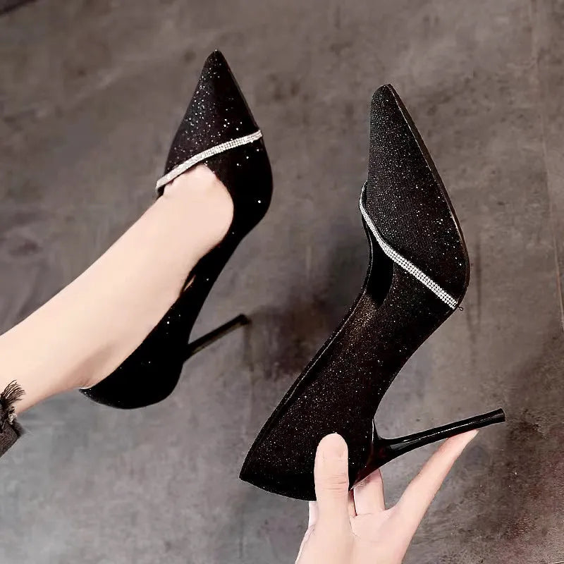 Women's black and gold stiletto high heels with pointed toe design and low-cut silhouette