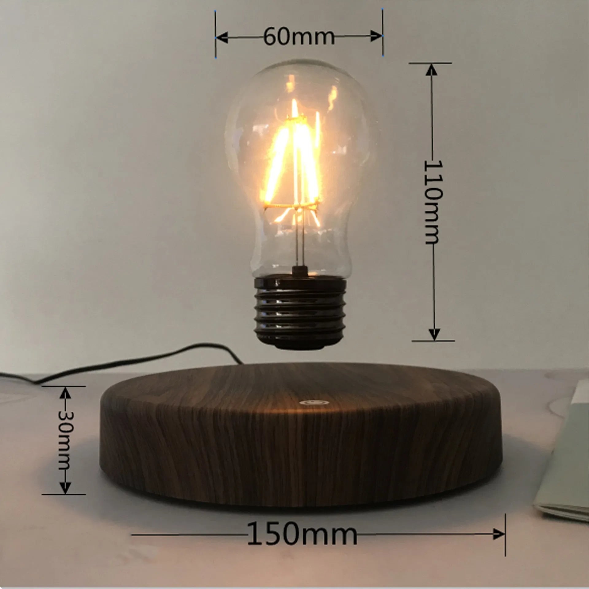 Magnetic levitation bulb night light in solid wood colour floating above plastic base