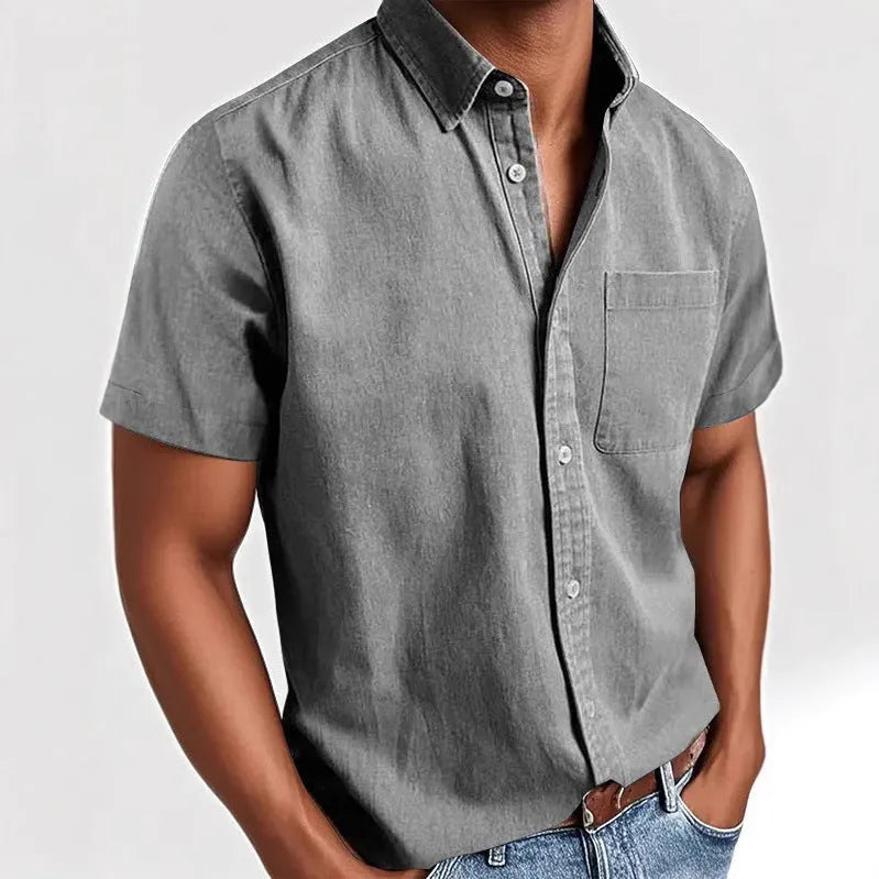 Man wearing a solid colour short-sleeved shirt with a polo collar and a single chest pocket.