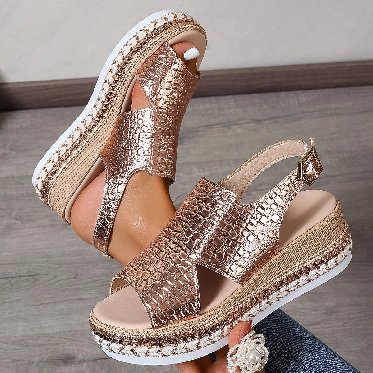 Gold women's Roman sandals with round toe, ankle buckle, and hollow-out design on a rubber sole.