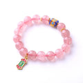 Pink strawberry quartz crystal bracelet with hand-woven beads, Ruyi charm, and letter charms.