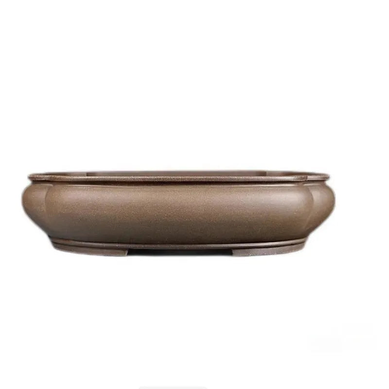 Handmade antique papaya-shaped purple clay flower pot on a table.