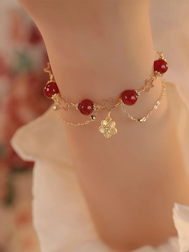 Close-up of a red agate double layer women's bracelet with floral and peach blossom motifs.
