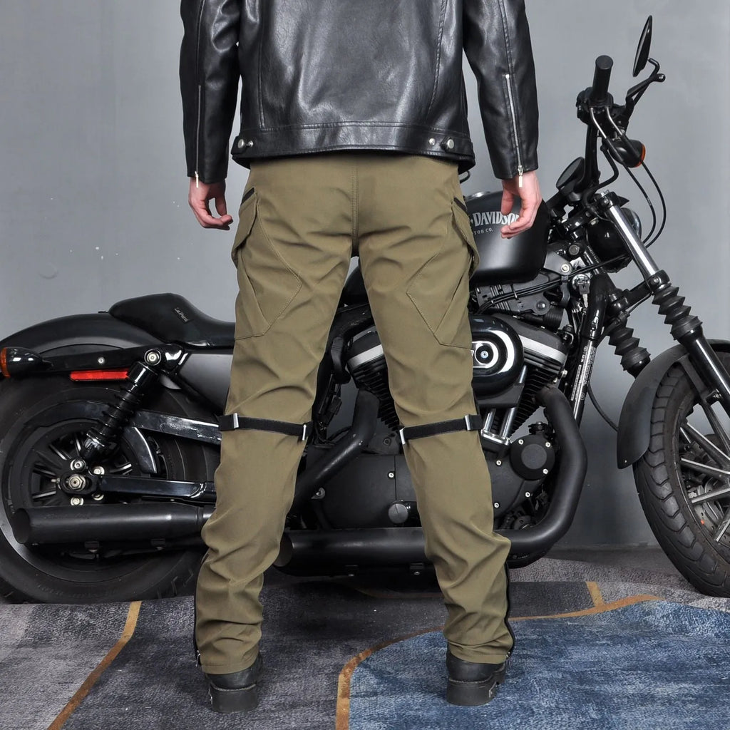 Man wearing green waterproof motorcycle trousers with belt and protective gear for cycling.