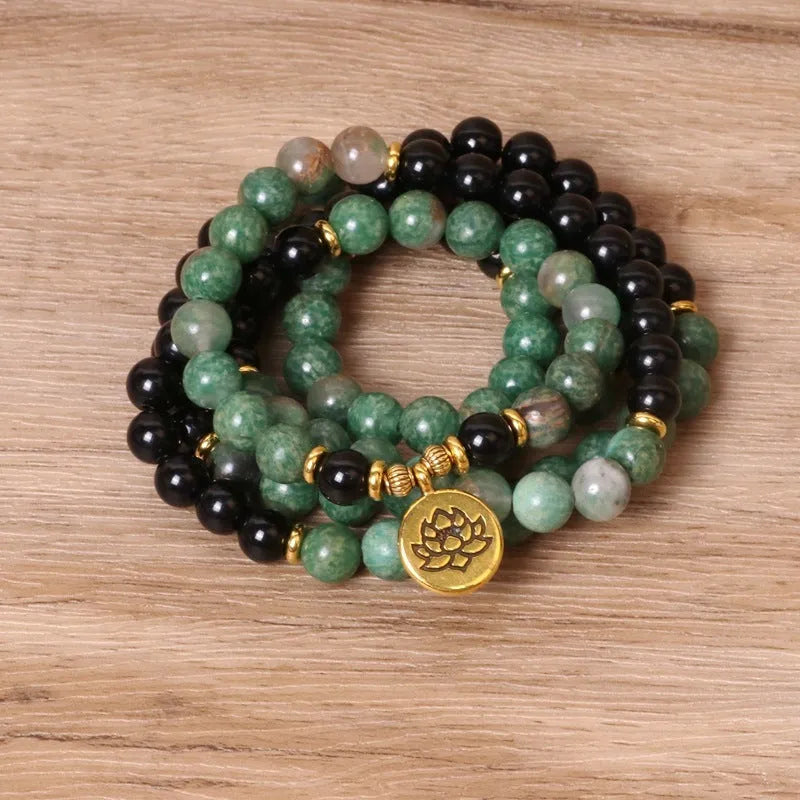 Green and black alloy bead elastic bracelet on a black stretch cord.