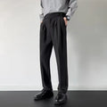 Men's apricot and black straight leg loose fit trousers on a hanger, showing the polyester fabric.