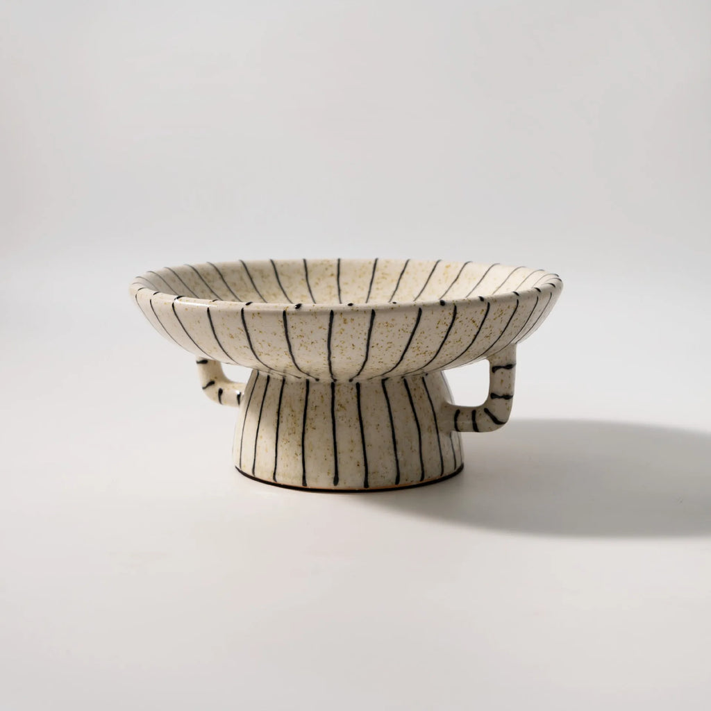 Black and white striped synthetic resin fruit plate on a table.
