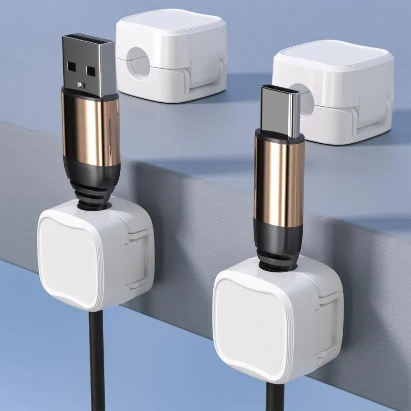 White and black magnetic under-desk cable clips organising various cables with adhesive backing